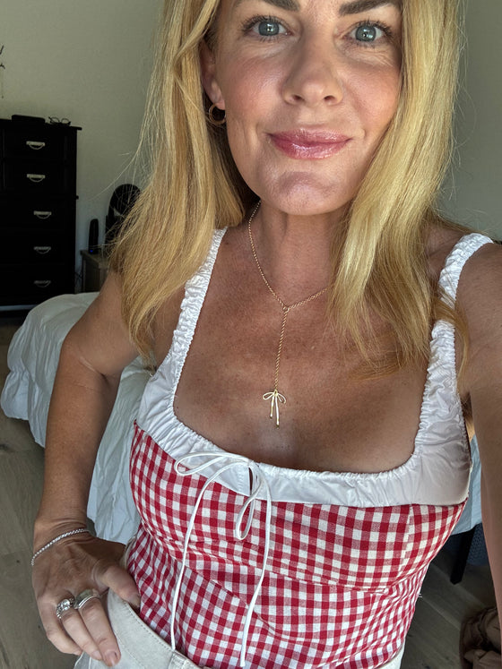Woman wearing a red and white checkered apron indoors.